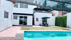 a house with a swimming pool in the yard at KingsLanding in Morelos