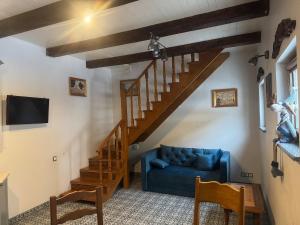 a living room with a blue couch and a wooden staircase at Чарунки днів in Mukacheve