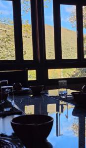 a table with bowls on top of a table with windows at Refúgio in Ouro Preto