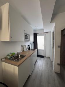 a kitchen with a sink and a counter top at Apartamentos Nueva Berria in Santoña