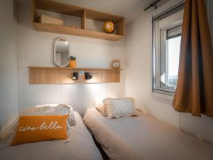 a small bedroom with a bed and a window at Camping Le Clos Des Pins in Longeville-sur-Mer +36 photos