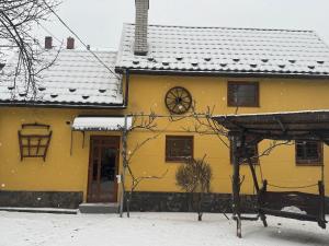 a yellow house with snow on the roof at Чарунки днів in Mukacheve