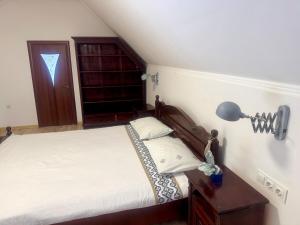 a bedroom with a bed and a desk with a lamp at Чарунки днів in Mukacheve