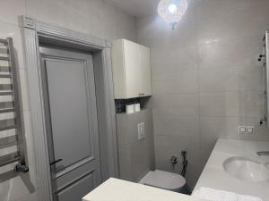a white bathroom with a toilet and a sink at Чарунки днів in Mukacheve +13 photos