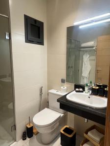 a bathroom with a toilet and a sink and a tv at Un moment d'évasion in Rabat