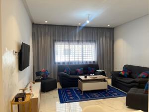 a living room with a couch and a table at Un moment d'évasion in Rabat