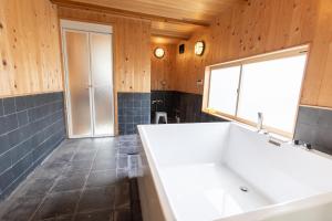 a bathroom with a white tub and a window at 愛犬と泊まれる一棟貸しviilaはBBQグリル無料利用可能サーフィンや釣りの拠点として in Kashima +72 photos