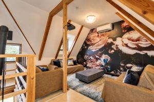 a living room with a large painting on the wall at 愛犬と泊まれる一棟貸しviilaはBBQグリル無料利用可能サーフィンや釣りの拠点として in Kashima