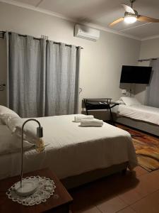 a bedroom with a bed and a lamp on a table at Merwenstein - Farm House, Cottages, Studio-Units in Bonnievale