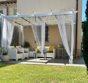 a pergola with white curtains on a patio at Piccola Dimora B&B in Lucca