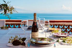 a bottle of wine sitting on a table with glasses at Villa Fuenti Bay - Amalfi Coast in Cetara