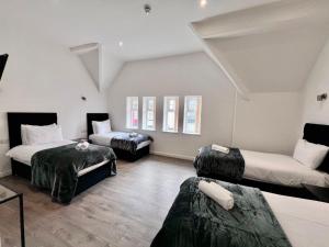a room with two beds and a couch in it at The Anfield Hotel in Liverpool