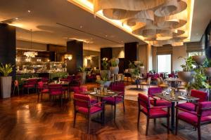 a restaurant with purple chairs and tables and a bar at JW Marriott Hotel Muscat in Muscat