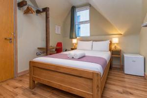 a bedroom with a bed with two towels on it at The Nest Boutique Hostel in Galway