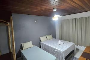 a room with two beds and a table and chairs at Sossego Real: Casa Solo C/ Banheira Ofuro in Ilhabela +43 photos