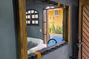 a mirror with a view of a bed in a room at Sossego Real: Casa Solo C/ Banheira Ofuro in Ilhabela