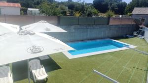 two umbrellas and a swimming pool on a backyard at Hostel Boente in Boente +18 photos