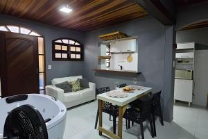 a kitchen and living room with a tub and a table at Sossego Real: Casa Solo C/ Banheira Ofuro in Ilhabela