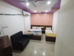 a small room with two beds and a chair at Hotel Apex in Mahesāna