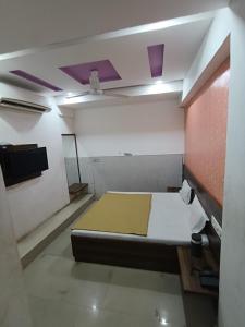 a room with a bed and a tv in it at Hotel Apex in Mahesāna