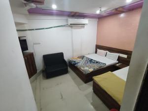 a room with two beds and a chair in it at Hotel Apex in Mahesāna