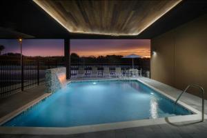a swimming pool with a sunset in the background at Fairfield Inn & Suites by Marriott Melbourne Beach in Melbourne