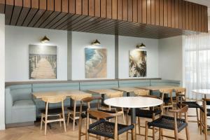 a restaurant with tables and chairs and paintings on the wall at Fairfield Inn & Suites by Marriott Melbourne Beach in Melbourne