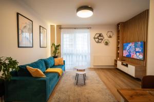 a living room with a blue couch and a table at JM Apartment in Poprad