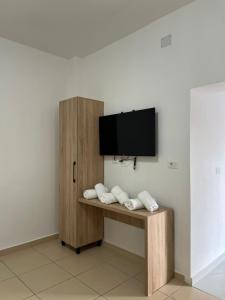 a room with a desk with a tv on a wall at Aer Rooms Peshkopi in Peshkopi +6 photos