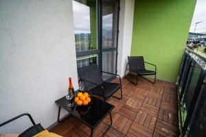 a balcony with two chairs and a table with oranges on it at JM Apartment in Poprad