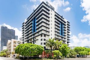 a tall building with a blue sign on it at Aloft by Marriott Miami - Brickell in Miami