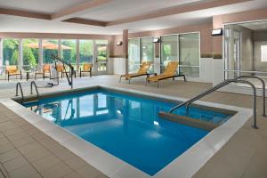 a pool with blue water in a hotel room at Courtyard Milwaukee Airport in Milwaukee