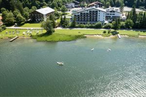 an aerial view of a lake with two boats in it at Arabella Alpenhotel am Spitzingsee, a Tribute Portfolio Hotel in Spitzingsee