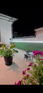a patio with a table and chairs and flowers at Aer Rooms Peshkopi in Peshkopi