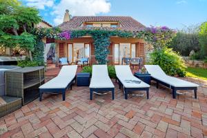 a patio with tables and chairs in front of a house at Domus de pedra in Marina di Portisco