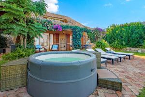 a backyard with a hot tub and chairs and a house at Domus de pedra in Marina di Portisco +41 photos
