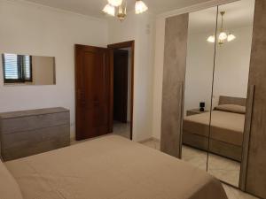 ein Schlafzimmer mit einem Bett, einer Kommode und einem Spiegel in der Unterkunft Dolce Onda in Bolsena