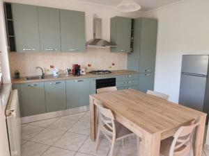 eine Küche mit einem Holztisch und eine Küche mit grünen Schränken in der Unterkunft Dolce Onda in Bolsena