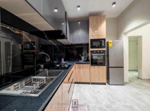a kitchen with a sink and a refrigerator at Rosedale luxury apartment in Ashouman