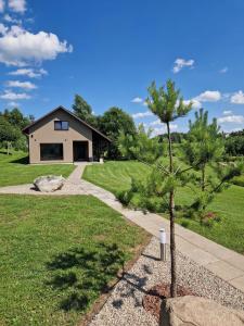 a small pine tree in front of a house at Gardenvillage house in Daržininkai