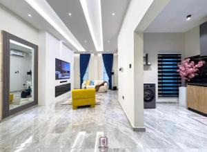 a living room with a yellow chair and a couch at Rosedale luxury apartment in Ashouman