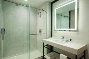 a bathroom with a sink and a shower with a mirror at Four Points by Sheraton Manhattan Midtown West in New York +18 photos