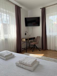 a bedroom with a bed with two white towels on it at Casa Crisan in Topliţa