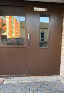 a brown door with a window on a building at White Sun Apartment in Aizkraukle