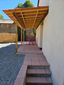 a wooden pergola on the side of a building at Lazy Days Gite in Rancon