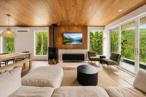 a living room with a couch and a table at Mountain - Sauna - Camp de base du Massif in Saint-Philémon