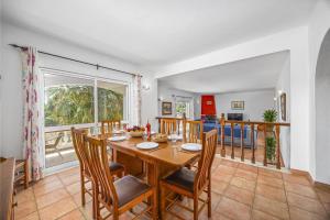 a dining room with a wooden table and chairs at Villa Ricardo by Villa Plus in Carvoeiro