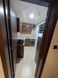 a small kitchen with wooden cabinets and a sink at Kroft Residence in Lekki