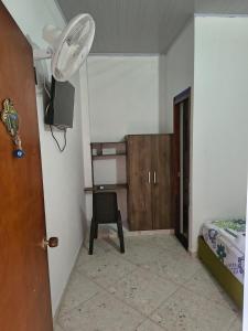 a room with a bedroom with a fan and a chair at Hotel Mar Azul in Acacías