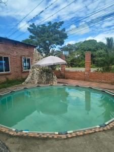 a large swimming pool with an umbrella and an umbrella at Hotel Mar Azul in Acacías